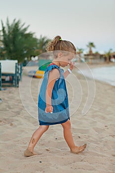 Little young girl playing on sea coast