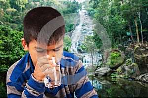 Littleboy drinking water on nature background