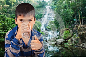 Littleboy drinking water on nature background