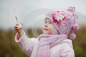 A littlegirl blows bubbles in autumn