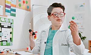The littlest of things matter most in science. an adorable young school boy learning about molecules in science class at photo