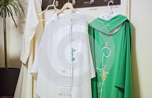 Liturgical clothing and vestments of the priest hang on wall clothes horse