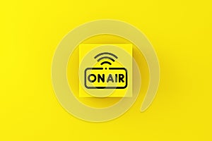 Live broadcasting and news concept. On air symbol on a yellow cube block