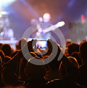 live concert with a guitarist and the fan with smart phone