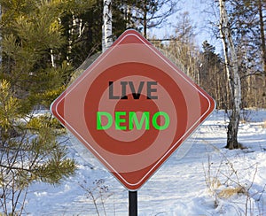 Live demo symbol. Concept words Live demo on beautiful red road sign. Beautiful forest snow blue sky background. Copy space.