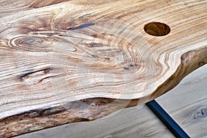Live edge elm desk with metal base in a modern home office. Details close-up