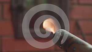 Live fire from a blowtorch against a brick furnace. Closeup