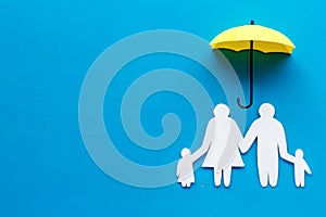 Live insurance concept. Family silhouette protected by umbrella on blue background top-down copy space