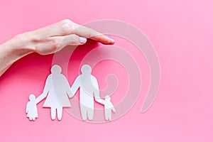 Live insurance concept. Family silhouette under palm on pink background top-down copy space