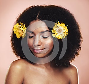 Live life in full bloom. Studio shot of a beautiful young woman posing with flowers in her hair.