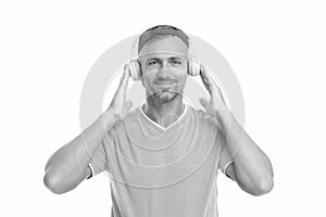 Žít život hlasitý. pěkný chlap oblečení sluchátka na bílém. zralý muž poslouchat na hudba v sluchátka. sluchátka 