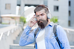 Live life loud with headphones. Hipster wear headphones outdoors. Bearded man listen to music in headphones. New