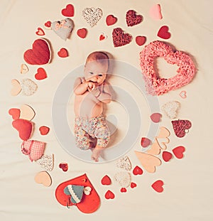 Live in love. Family. Child care. Small girl among red hearts. Sweet little baby. New life and birth. Love. Portrait of