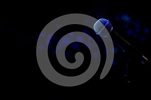 Live music background with microphone and stage blue lights bokeh effect