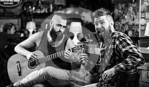 Live music concert. Acoustic performance in pub. Hipster brutal bearded with friend in pub. Man play guitar in pub