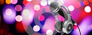 Live music concert concept. Microphone and headphones on stand on bokeh background, banner. 3d illustration
