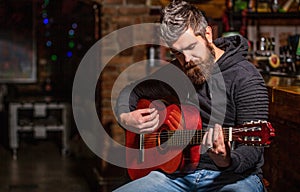 Live music. Guitars and strings. Bearded man playing guitar, holding an acoustic guitar in his hands. Music concept