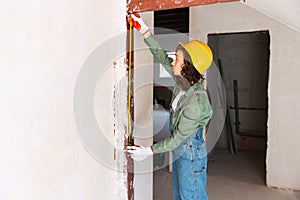 Live portrait of young woman, builder wearing helmet using different work tools at a construction site. Gender equality