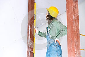 Live portrait of young woman, builder wearing helmet using different work tools at a construction site. Gender equality