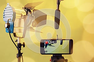 Live Stream Video Multimedia Concept.smartphone , microphone and reflectors on the Yellow background