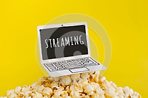 live streaming concepts with text on paper art laptop and.pop corn on pastel color photo