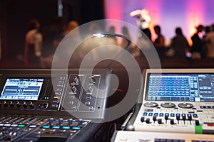 Live theater concert show sound video music control console with scene lights background. Sound engineer mixer