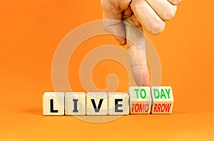 Live today not tomorrow symbol. Businessman turns wooden cubes and changes word Live tomorrow to Live today. Beautiful orange
