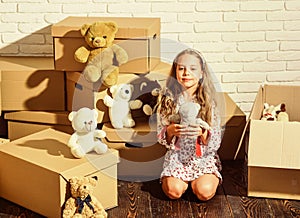 Live the uptown urban lifestyle. purchase of new habitation. happy little girl with toy. happy child cardboard box