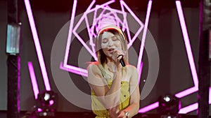 Live vocal performance of emotional singer on background with rose led lights.