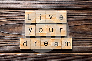 Live your dream word written on wood block. live your dream text on wooden table for your desing, concept