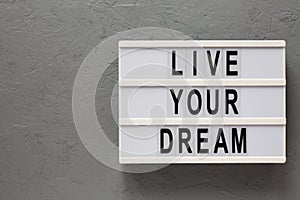 `Live your dream` words on a modern board on a gray background, top view. Overhead, from above, flat lay. Copy space
