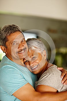 Live your life with love and laughter. Portrait of a mature couple embracing at home.