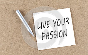 LIVE YOUR PASSION text on sticky note on a cork board with pencil