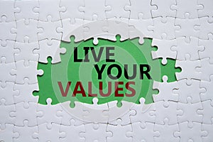 Live your values symbol. Concept words Live your values on white puzzle. Beautiful green background. Business and Live your values