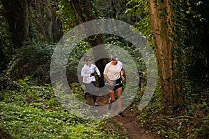 Lively man and woman jogging in forest