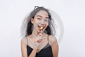 A lively and perky asian woman holding a lollipop.  on a white background