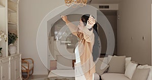 Lively woman dancing alone in fashionable living room at home