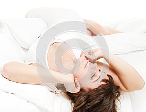 Lively woman is relaxing in the bed