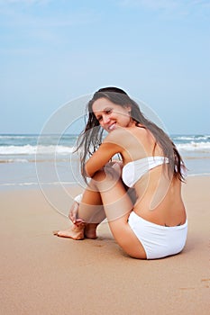 Lively woman sitting on the sand photo