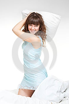 Lively young woman with pillow photo