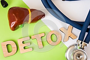 Liver detox concept photo. Word detox of volumetric letters is near 3D liver model and medical stethoscope. Medical diet program