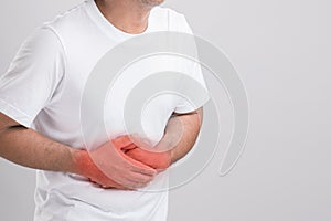 Liver or kidney problem concept : Man holding hand on belly and feeling a pain in liver or . Studio shot isolated on grey