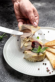 Liver pate. Male hands smear homemade paste on toasted bread. Fresh homemade pate. Food recipe background. Close up