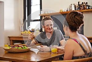 Living all natural. Shot of a happy couple with dreadlocks sitting down to breakfast.