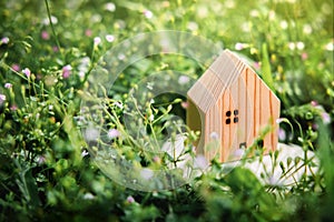 Living in a Harmony Lifestyle Concept. Wooden House Model on Green Grass. Close to Nature