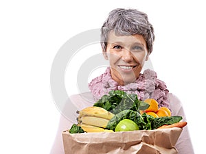 Living life the healthy way. Studio portrait of a mature woman holding a brown paper bag filled with fruit and