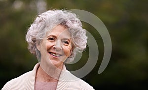 Living life with a smile. Portrait of a smiling senior woman standing outside.