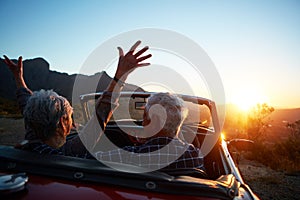 Living in the moment. a joyful senior couple enjoying the sunset during a roadtrip.