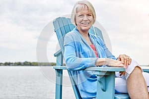 Living the retirement of my dreams. Portrait of a happy senior woman relaxing on a chair outside.