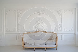 Living room with antique stylish light sofa on luxury white wall design bas-relief stucco mouldings roccoco elements